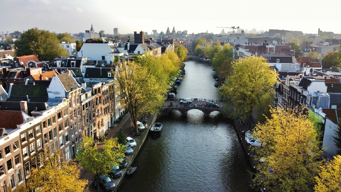 Aerial view of an Amsterdam canal district, the built form, water and greenery that satellite and open-data signals describe.